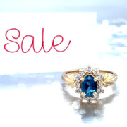 Lady's Yellow 14 Karat Princess Di Fashion Ring Size 7 With One 0.80Ct Oval Blue Blue Topaz And 12=0.60Tw Round G/H Vs2- Si1 Diamonds